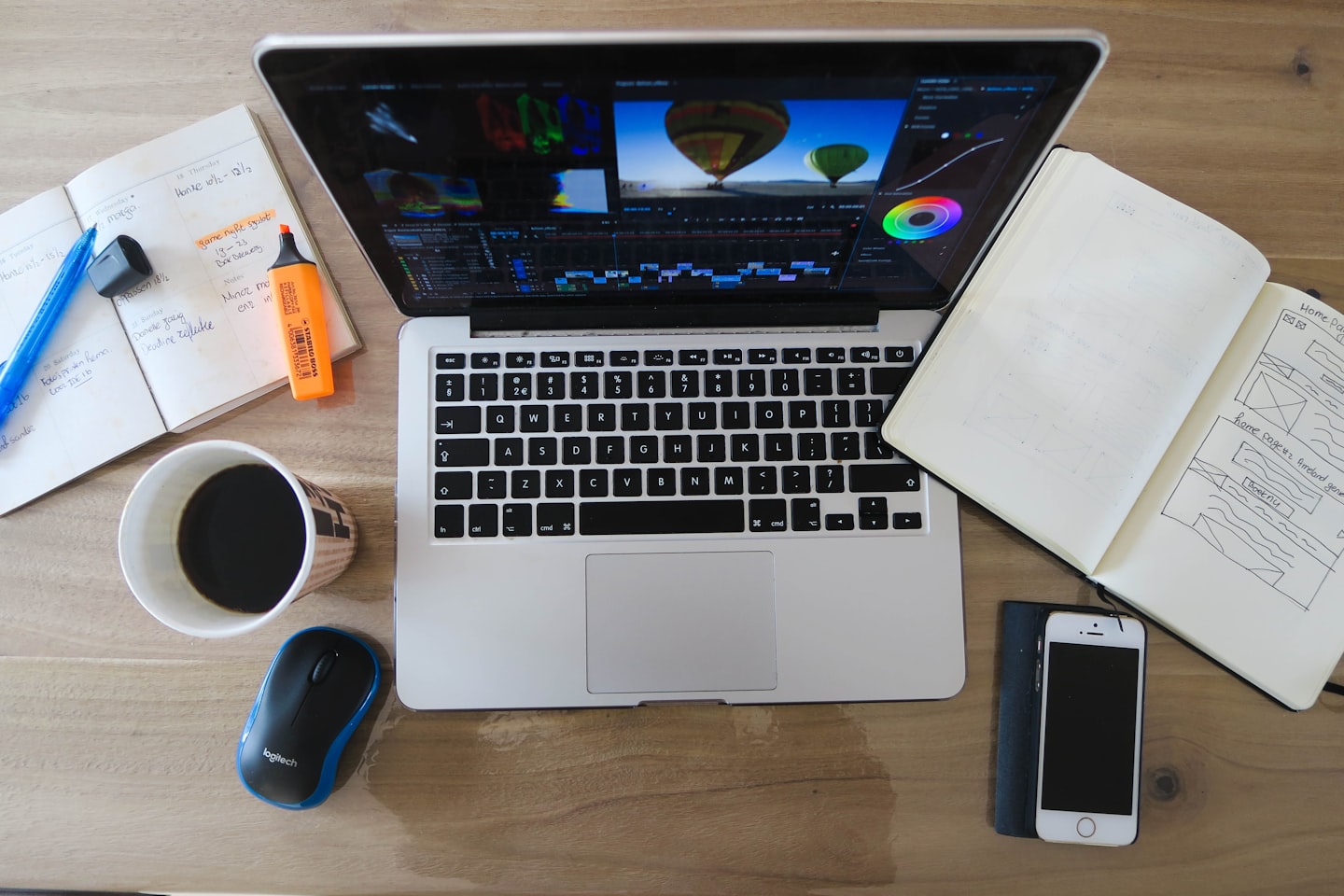 Creative workspace with a camera, notebook, and laptop for planning a photography website