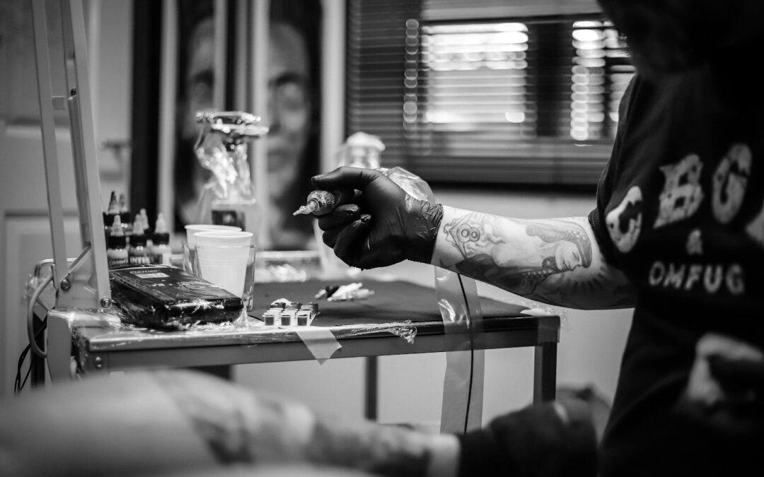 Tattoo artist in a modern studio reviewing an appointment booking interface for client scheduling