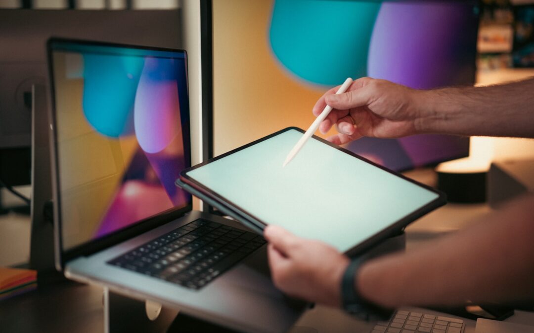 Art studio operator reviewing class scheduling and payment tools on a laptop in a creative workspace.