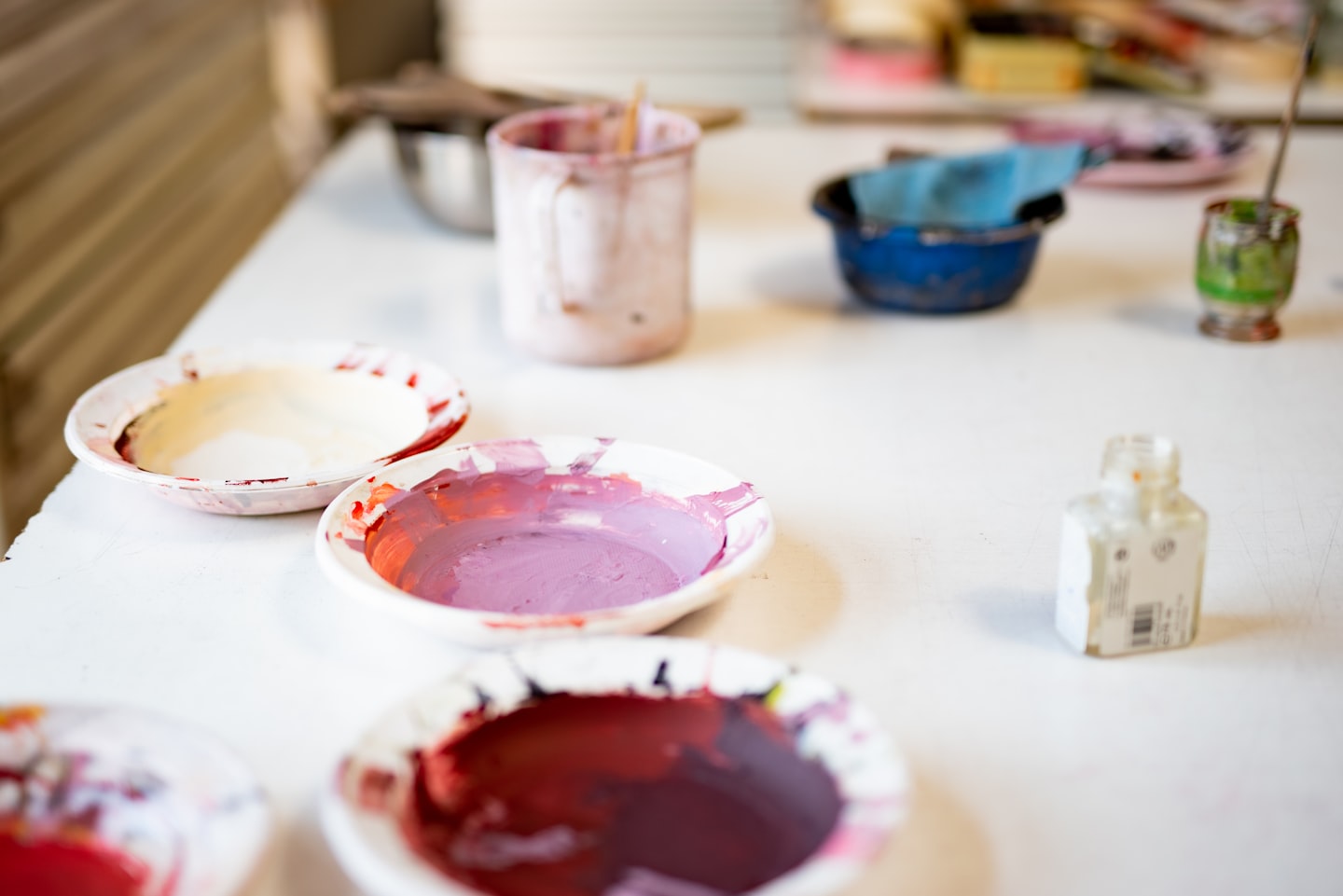 An art instructor working in a bright studio workspace while managing upcoming classes.