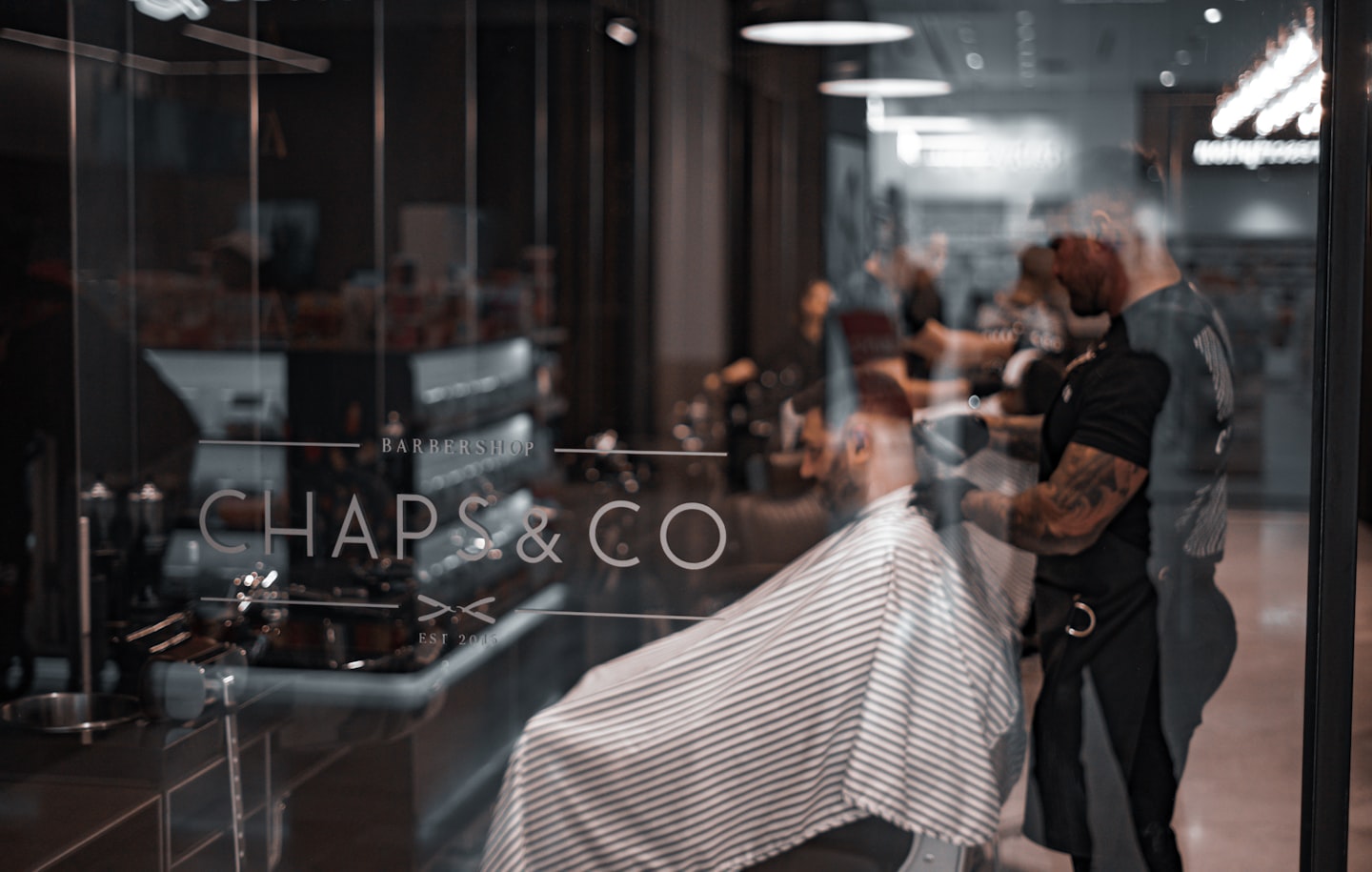 Barber and client in a barbershop, illustrating repeat visits and rebooking