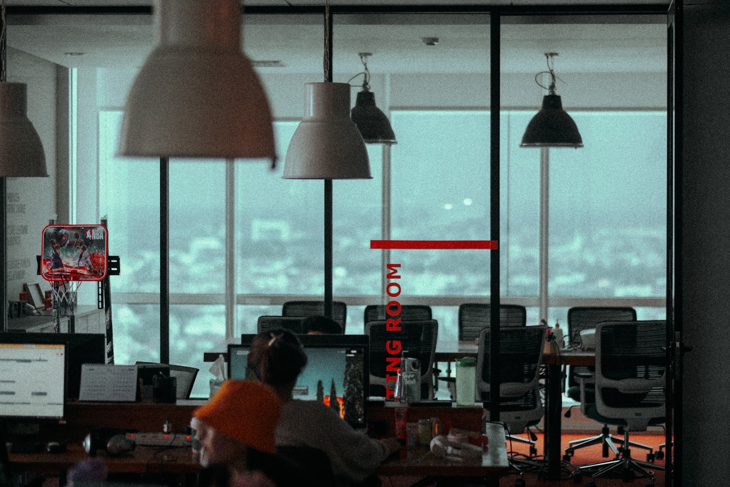 a group of people sitting at a desk with a large window